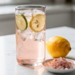Pale pink Himalayan salt electrolyte drink with lemon and mint for sauna recovery