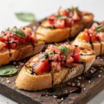 Close up of vibrant tomato basil bruschetta with pink Himalayan salt on rustic bread