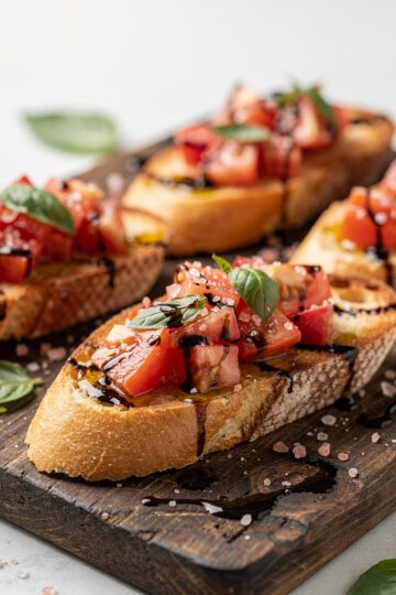 Close up of vibrant tomato basil bruschetta with pink Himalayan salt on rustic bread