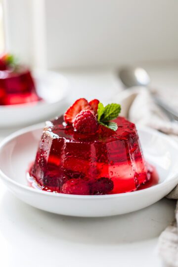 Ruby cherry gelatin with mint leaves and glossy texture