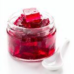Glossy ruby hibiscus gelatin on white marble surface