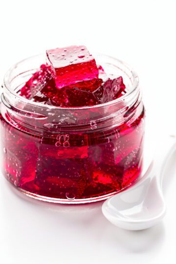 Glossy ruby hibiscus gelatin on white marble surface