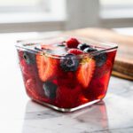 Pale pink gelatin dessert with fresh blueberries and raspberries