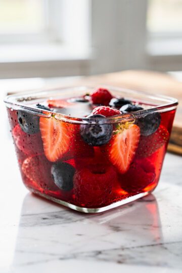 Pale pink gelatin dessert with fresh blueberries and raspberries