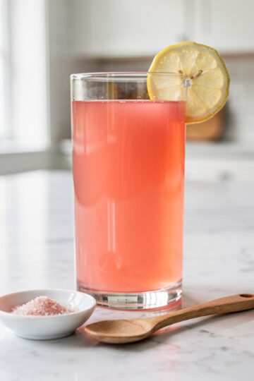 Warm pink gelatin drink on white marble countertop