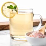 Clear pink salt drink with lemon on marble countertop
