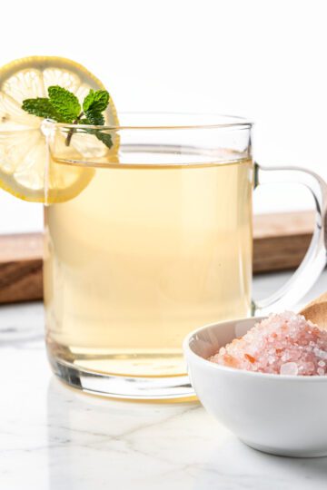 Clear pink salt drink with lemon on marble countertop