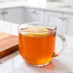 Warm tangy gelatin drink in clear glass mug on marble