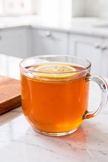 Warm tangy gelatin drink in clear glass mug on marble