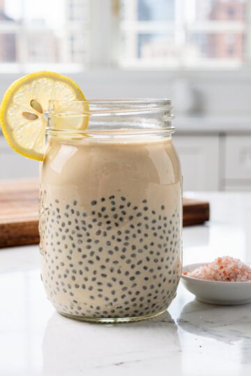 Two glass jars of chia gelatin on marble countertop.