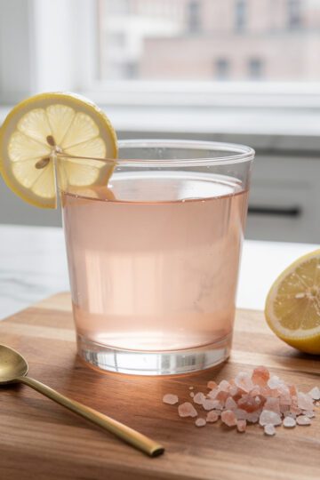 Pink salt recipe for neuropathy served as warm pink Himalayan salt lemon water in a clear glass