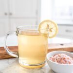Warm gelatin drink with pink salt and lemon slice