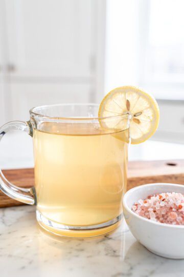 Warm gelatin drink with pink salt and lemon slice